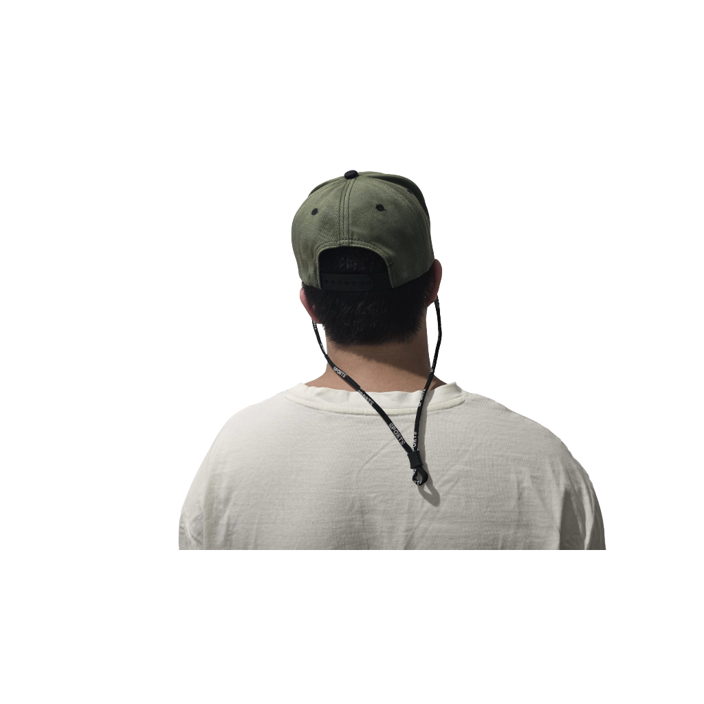 Person wearing a green cap with a black strap over a white background