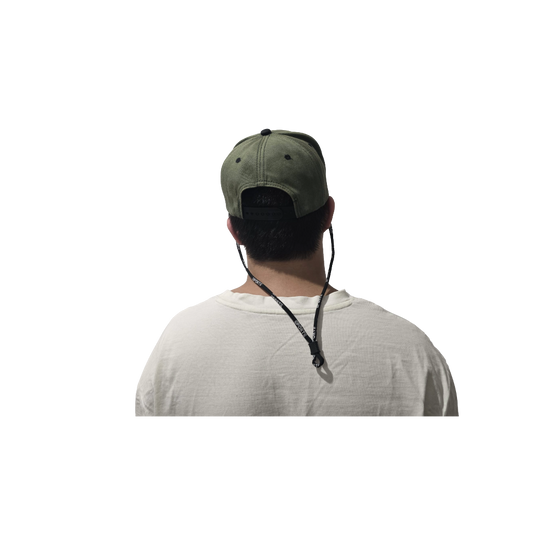 Person wearing a green cap with a black strap over a white background